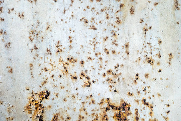 Rusty metal wall with cracked white paint