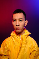 Asian man in a yellow suit of chemical protection on a colored trendy background. Conceptual fashion fashion shooting.