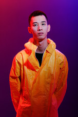 Asian man in a yellow suit of chemical protection on a colored trendy background. Conceptual fashion fashion shooting.
