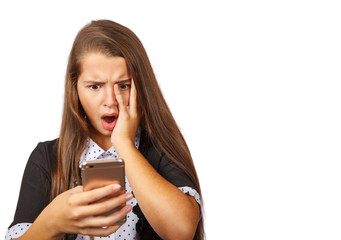 Fototapeta premium indignant teen girl looks at smartphone display