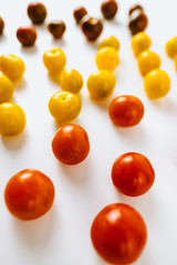 Varieties of cherry tomatoes background, isolated on white, abstraction
