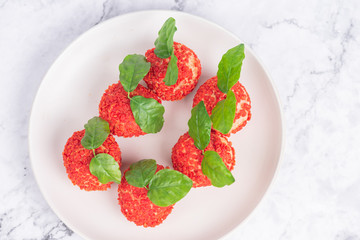 Red dessert like litchi on a white plate