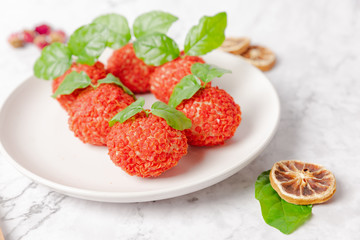 Red dessert like litchi on a white plate