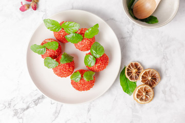 Red dessert like litchi on a white plate