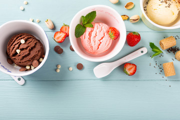 Homemade assorted ice cream on light blue wooden background. Healthy summer food concept. Top view, copy space.
