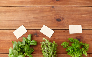 greens, spices or medicinal herbs concept - bunches of parsley, basil and rosemary on wooden boards