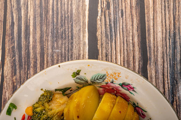 Vegetable salad in a white ceramic bowl on a wooden background. Close up.
