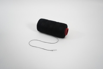 black sewing thread on a white background