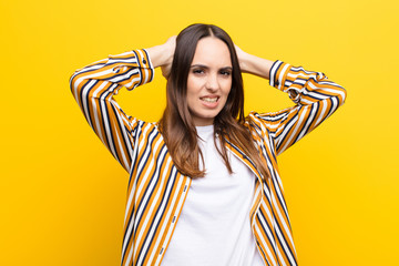 young pretty woman feeling stressed, worried, anxious or scared, with hands on head, panicking at...