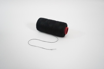 black sewing thread on a white background