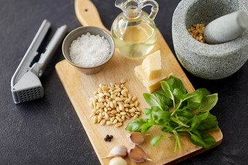 food cooking and culinary concept - parmesan cheese, pine nuts, vinegar and garlic for basil pesto...