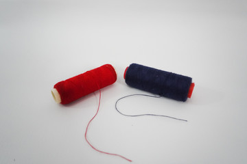 blue and red sewing thread on a white background