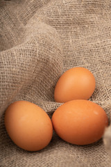 Chicken eggs on a background of rough homespun fabric. Country food.Close up.