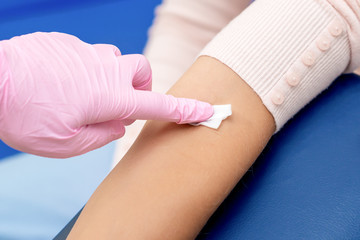 Nurse disinfecting arm skin.