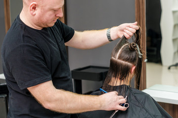 Hairdresser combing female hair.