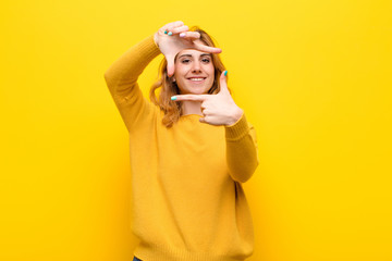 young pretty blonde woman feeling happy, friendly and positive, smiling and making a portrait or...