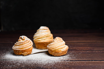 modern cruffins are made from puff croissants in the form of a muffin. on a dark background in powdered sugar. Copy space. the view from the top. close up