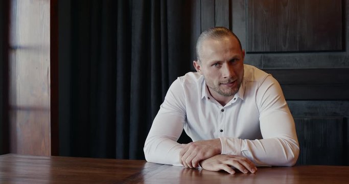 Video clip of nervous businessman fidgeting at table indoors