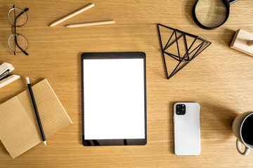 Business flat lay composition on the wooden desk with mock up tablet display, mobile phone, cup of...