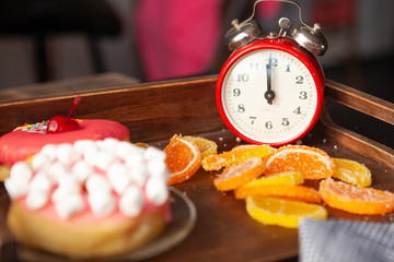 marshmallow pink donut and marmalade on a clock tray