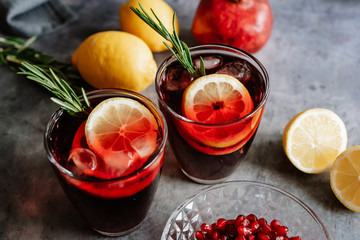 Pomegranate drink in a glass with lemon and rosemary