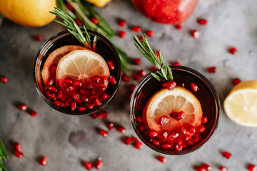 Pomegranate drink in a glass with lemon and rosemary