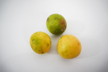 three fresh lemons on a white background