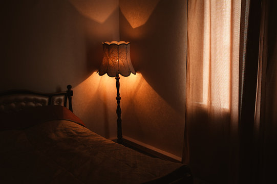 Bedroom Interior With A Bed And A Floor Lamp, Light From A Floor Lamp, Closed Curtains