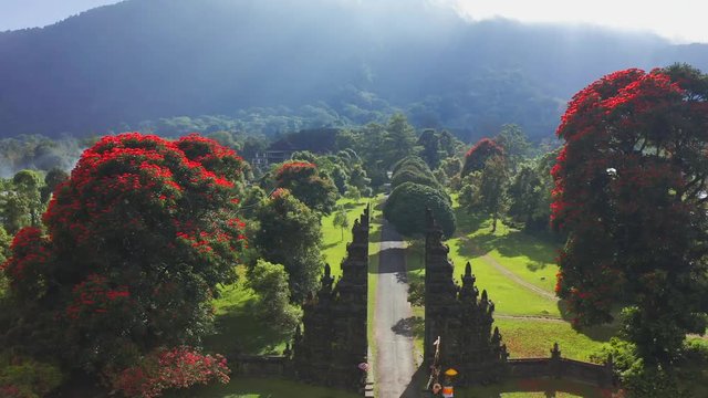 Aerial view of Ancient Bali style gate with pathway in garden. Aerial view 4K.
