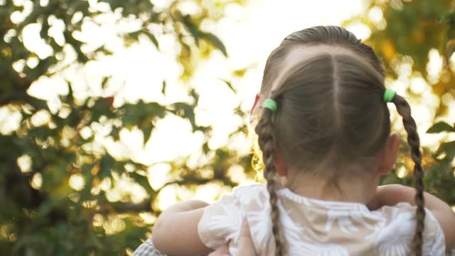 Portrait of father holding child girl in his hands and hugging each other outdoors. Dad cudding and kissing with his daughter. Father's day