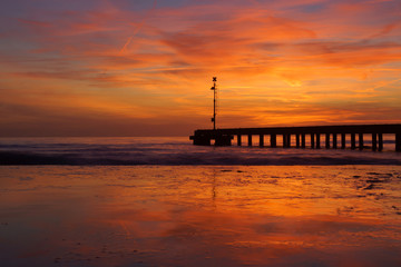 pier in a reflected sunset