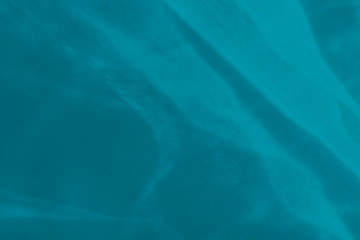 Trendy blue colored abstract background with light and shadows caustic effect. Light passes through a glass, water texture overlay