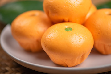 Pork dumpling in cartoon style,Pork bun like an orange in a white plate on the indoor dining table