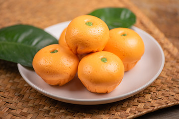 Pork dumpling in cartoon style,Pork bun like an orange in a white plate on the indoor dining table