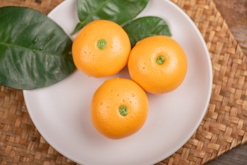 Pork dumpling in cartoon style,Pork bun like an orange in a white plate on the indoor dining table