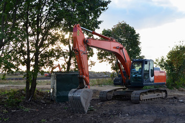 Bucked tracked excavator digs ground at a construction site for installing concrete storm pipes. Backhoe the digging pipeline ditch. Commercial and Public Civil Work Contracting, trenching, tamps soil