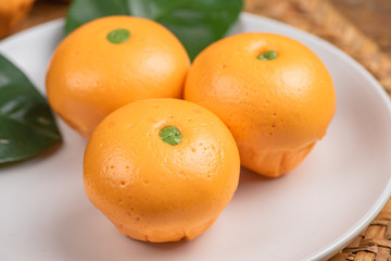 Pork dumpling in cartoon style,Pork bun like an orange in a white plate on the indoor dining table