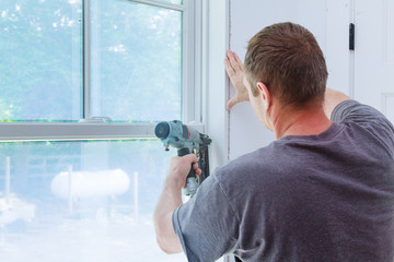 Worker installing trim around a window