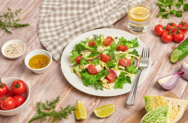 Fresh salad with cherry tomatoes, savoy cabbage, cucumeber on dish. Healthy summer salad vegetarian meal concept. Tasty mixed leaves, tomatoes and mix vegetable salad on wood background