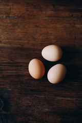 Three eggs on a brown background