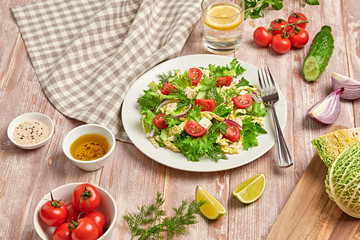 Fresh salad with cherry tomatoes, savoy cabbage, cucumeber on dish. Healthy summer salad vegetarian meal concept. Tasty mixed leaves, tomatoes and mix vegetable salad on wood background