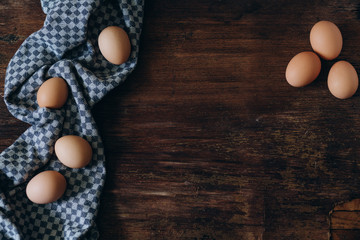 brown chicken eggs on a vintage background. On the side lies a blue linen cloth