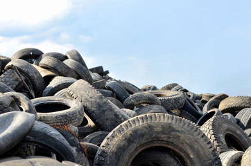 Industrial landfill for the processing of waste tires and rubber tyres. Pile of old tires and wheels for rubber recycling. Tyre dump