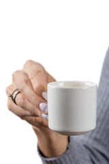 Cup of freshly brewed espresso in a beautiful elegant hand with a manicure and rings of a European girl in a grey wool sweater isolated on a white background.