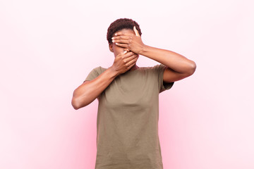 young pretty black womancovering face with both hands saying no to the camera! refusing pictures or...