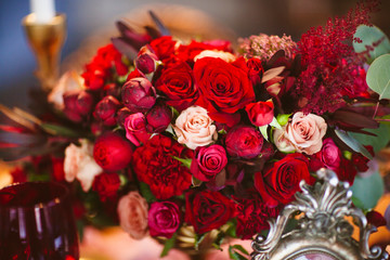 Floral arrangement with red and pink roses is on the table