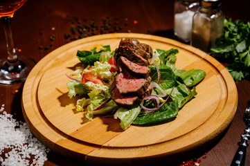 ham with lettuce on a wooden board on a table
