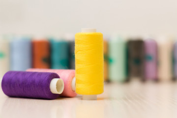 Sewing threads on wooden background