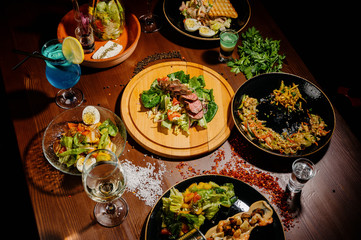 Many different delicious dishes on the table. Various snacks and antipasti on the table. Restaurant menu.