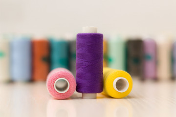 Sewing threads on wooden background